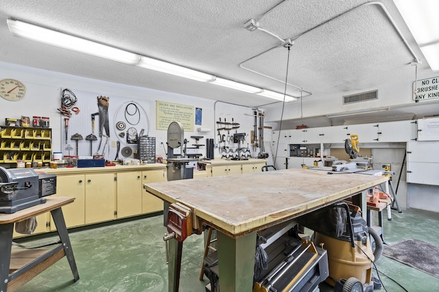 interior space featuring a workshop area and a textured ceiling