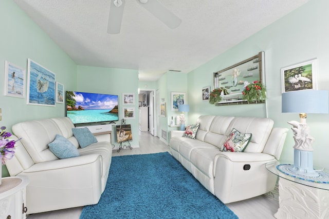 living room featuring a textured ceiling and ceiling fan