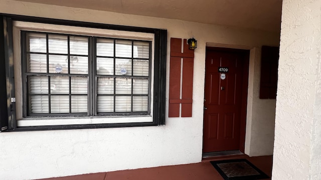 property entrance with stucco siding