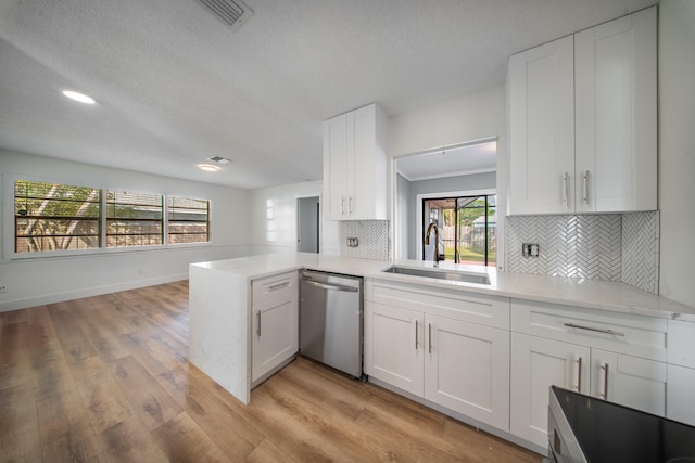 kitchen with white cabinetry, sink, stainless steel dishwasher, kitchen peninsula, and light hardwood / wood-style floors