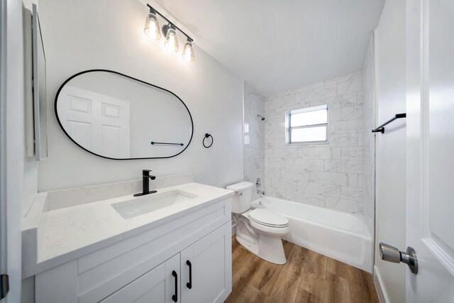 full bathroom featuring toilet, vanity, tiled shower / bath combo, and hardwood / wood-style flooring