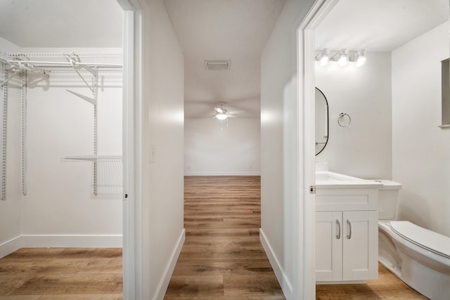 bathroom featuring ceiling fan, toilet, vanity, and hardwood / wood-style flooring