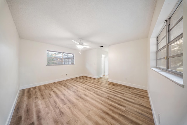 spare room with a textured ceiling and light wood-type flooring