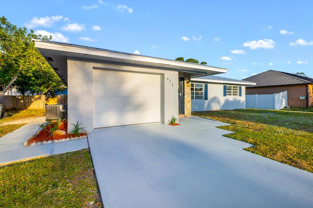 single story home featuring central AC unit, a garage, and a front yard