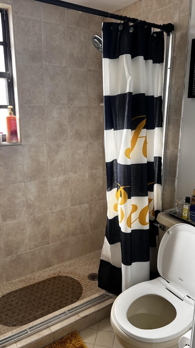 bathroom featuring tile patterned floors, a shower with curtain, and toilet