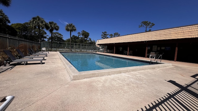 pool with a patio and fence