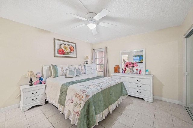 bedroom with light tile patterned floors, a textured ceiling, and ceiling fan