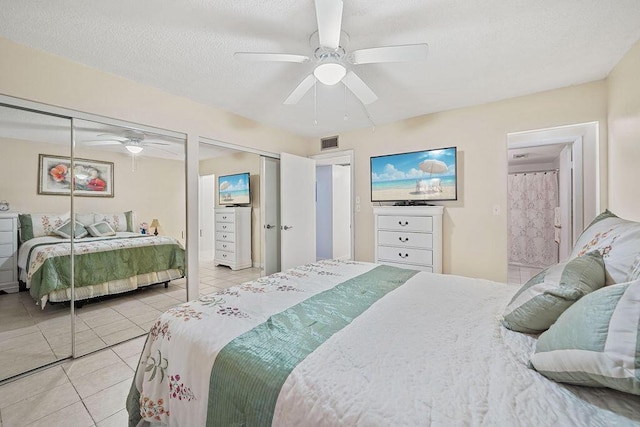 tiled bedroom with a textured ceiling and ceiling fan