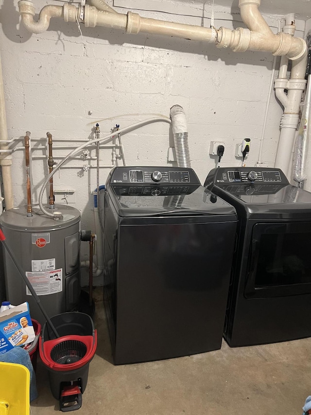 clothes washing area with washing machine and dryer and water heater