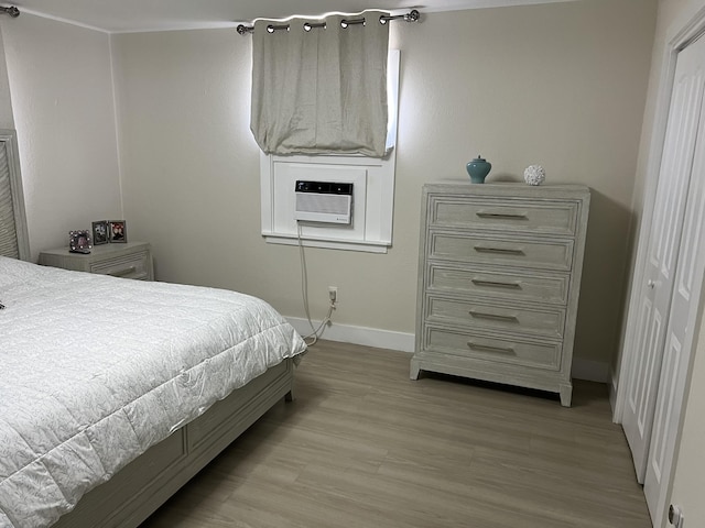 bedroom with cooling unit, light hardwood / wood-style flooring, and a closet