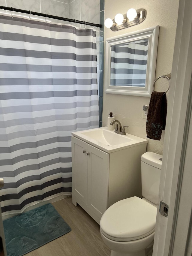 bathroom with hardwood / wood-style floors, vanity, toilet, and a shower with curtain