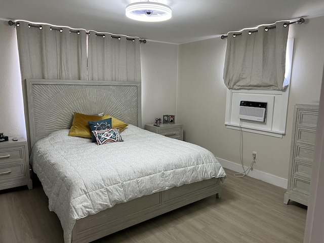 bedroom with cooling unit and wood-type flooring