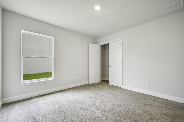 unfurnished bedroom with carpet flooring and a closet