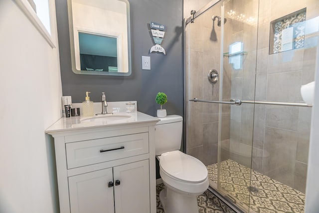 bathroom with vanity, a healthy amount of sunlight, an enclosed shower, and toilet