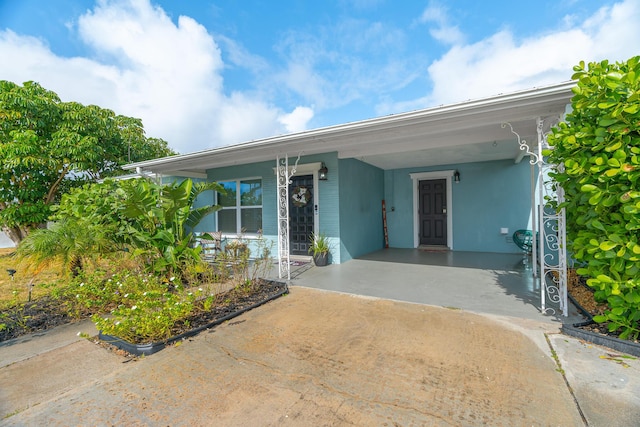 ranch-style house with a carport, covered porch, and driveway