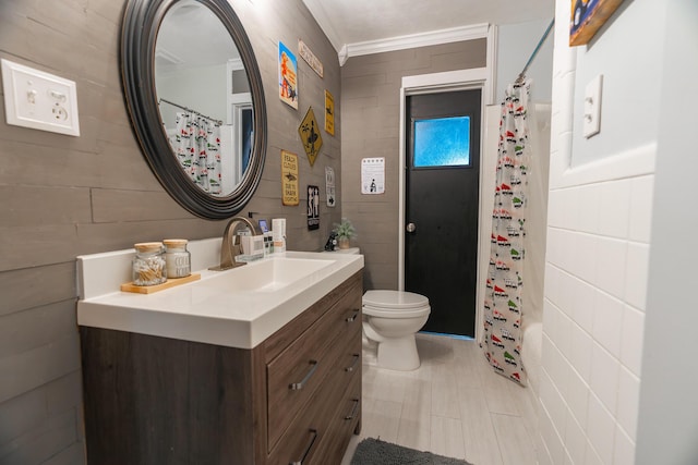 full bathroom with toilet, shower / bath combo with shower curtain, vanity, tile walls, and ornamental molding