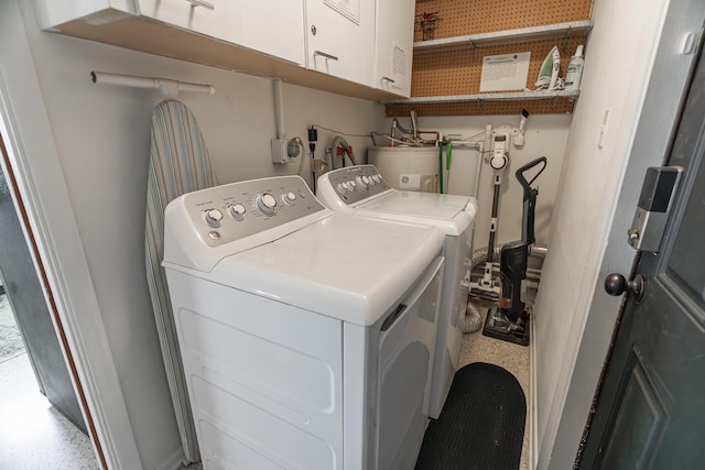 clothes washing area with separate washer and dryer, strapped water heater, and cabinets