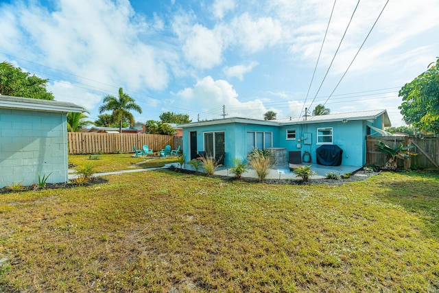 rear view of house with a lawn and a patio area