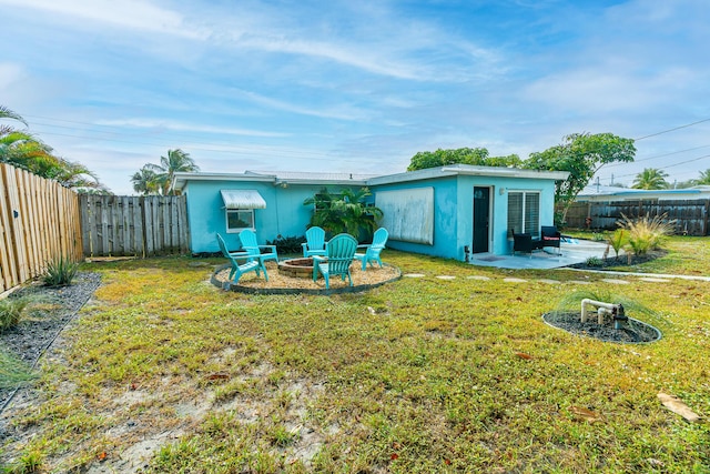 rear view of property with a patio, a fire pit, and a lawn