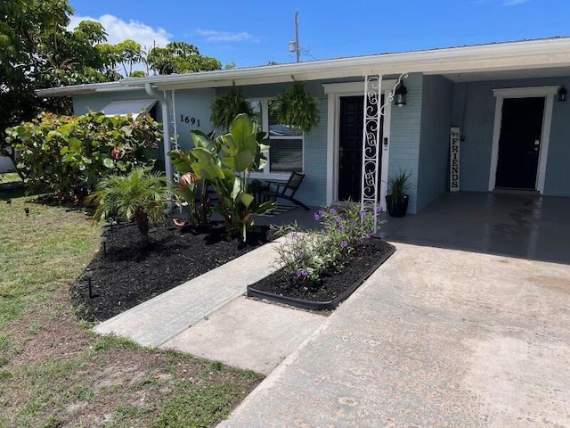 view of exterior entry with covered porch and a carport