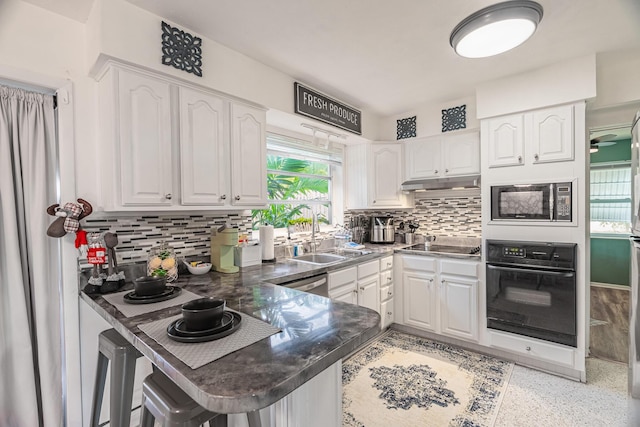 kitchen with black appliances, white cabinets, sink, tasteful backsplash, and kitchen peninsula