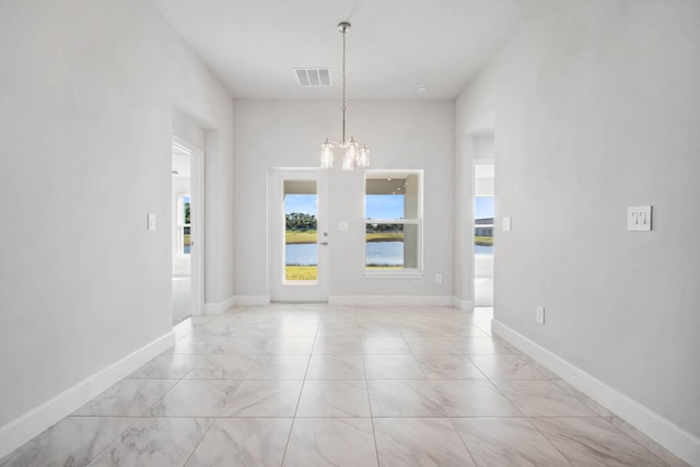 interior space featuring a water view and an inviting chandelier