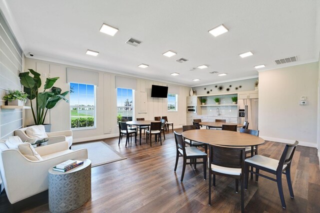 dining space with dark hardwood / wood-style flooring and crown molding