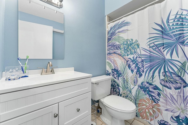 bathroom with tile patterned flooring, vanity, and toilet