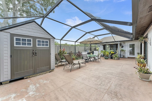 view of patio featuring glass enclosure and a storage unit