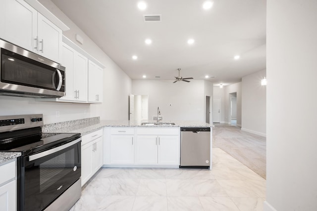 kitchen featuring kitchen peninsula, appliances with stainless steel finishes, ceiling fan, sink, and white cabinets