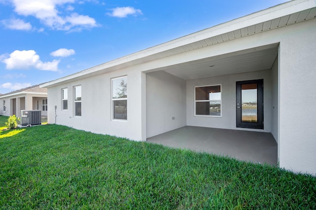 rear view of property featuring a lawn, a patio, and central AC unit