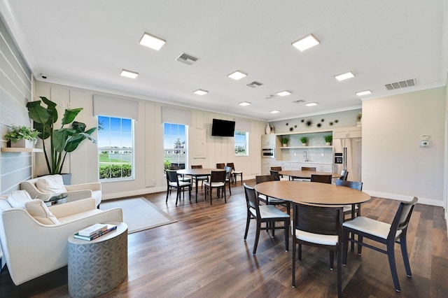 dining area with visible vents, dark wood-style flooring, and ornamental molding
