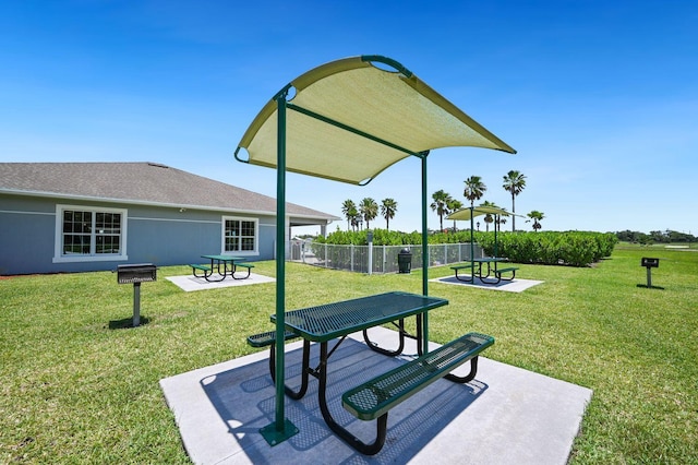 view of property's community with a lawn, a patio, and fence