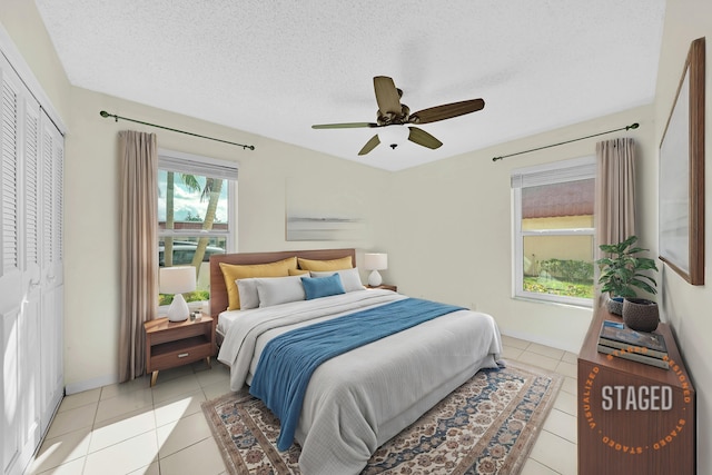 tiled bedroom with a textured ceiling, a closet, and ceiling fan