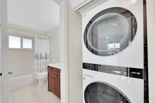 laundry room with light tile patterned floors and stacked washer and dryer