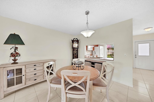 tiled dining space featuring sink and a textured ceiling