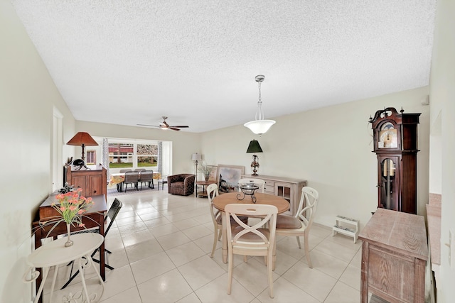 tiled dining room with ceiling fan and a textured ceiling