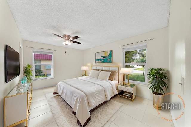 bedroom featuring light tile patterned floors, a textured ceiling, and ceiling fan