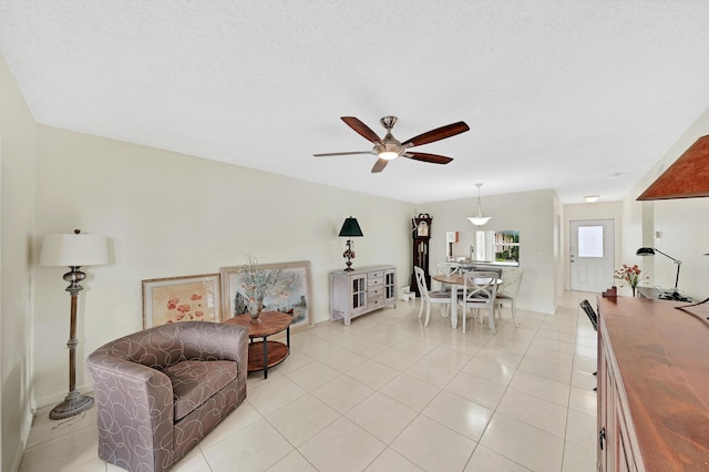 tiled living room featuring a textured ceiling and ceiling fan