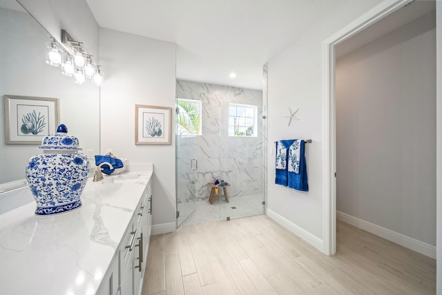 bathroom featuring vanity, an enclosed shower, and wood-type flooring