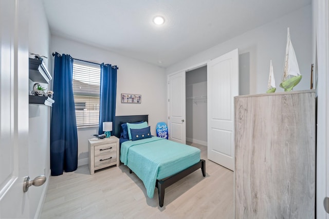 bedroom with light wood-type flooring and a closet