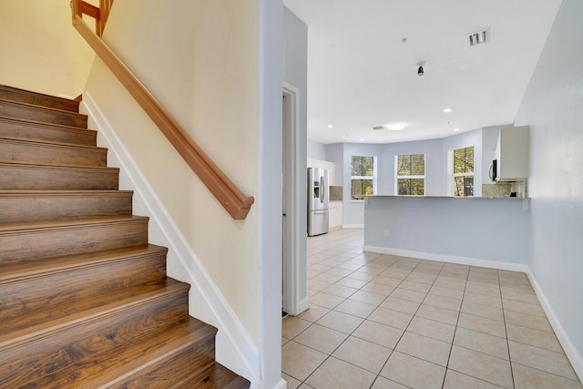 stairway with tile patterned floors