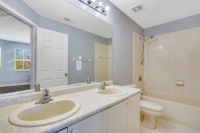 full bathroom featuring tile patterned flooring, tiled shower / bath combo, toilet, and vanity