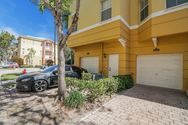 view of front of home with central air condition unit and a garage