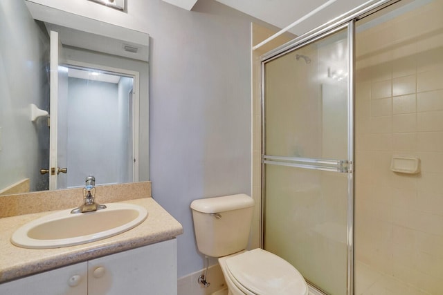 bathroom featuring vanity, toilet, and a shower with door