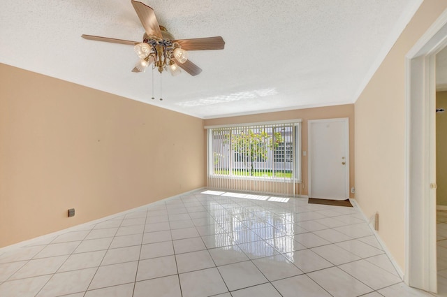 tiled spare room with a textured ceiling and ceiling fan