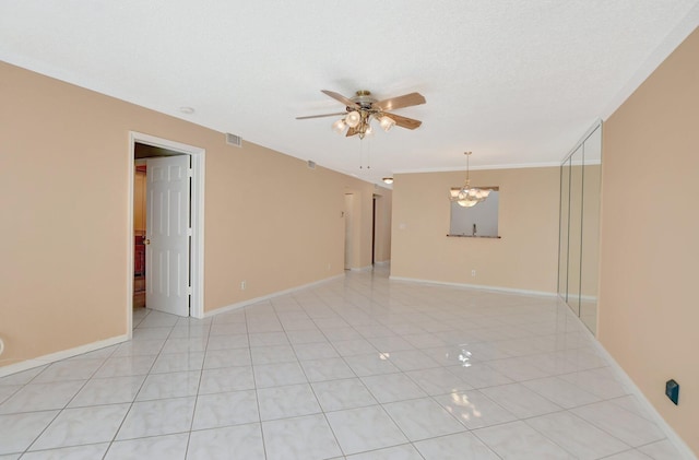 unfurnished room with a textured ceiling, ceiling fan with notable chandelier, ornamental molding, and light tile patterned flooring