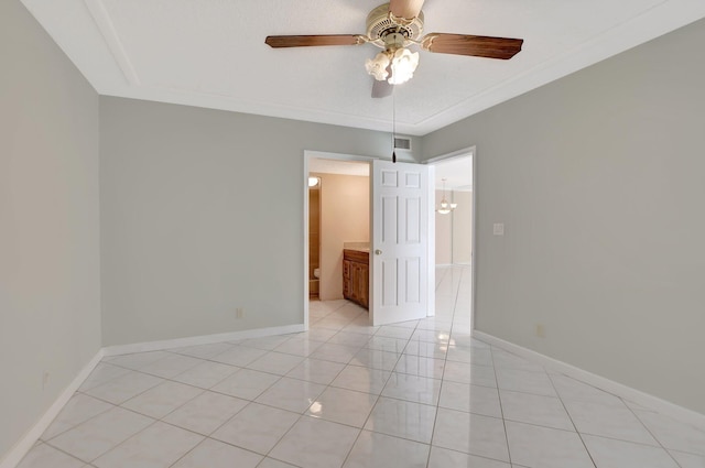 tiled spare room with ceiling fan and ornamental molding