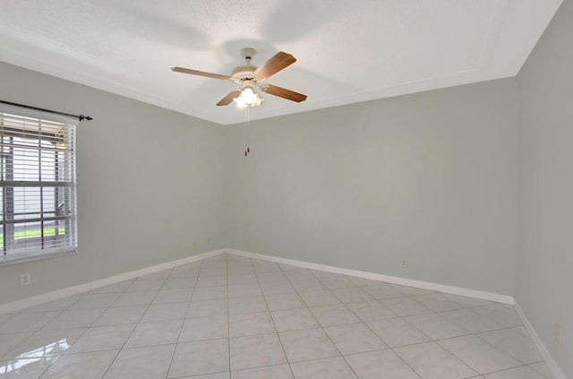 tiled empty room with ceiling fan and a textured ceiling