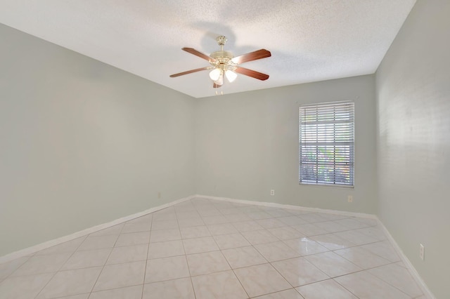 spare room with light tile patterned floors, a textured ceiling, and ceiling fan